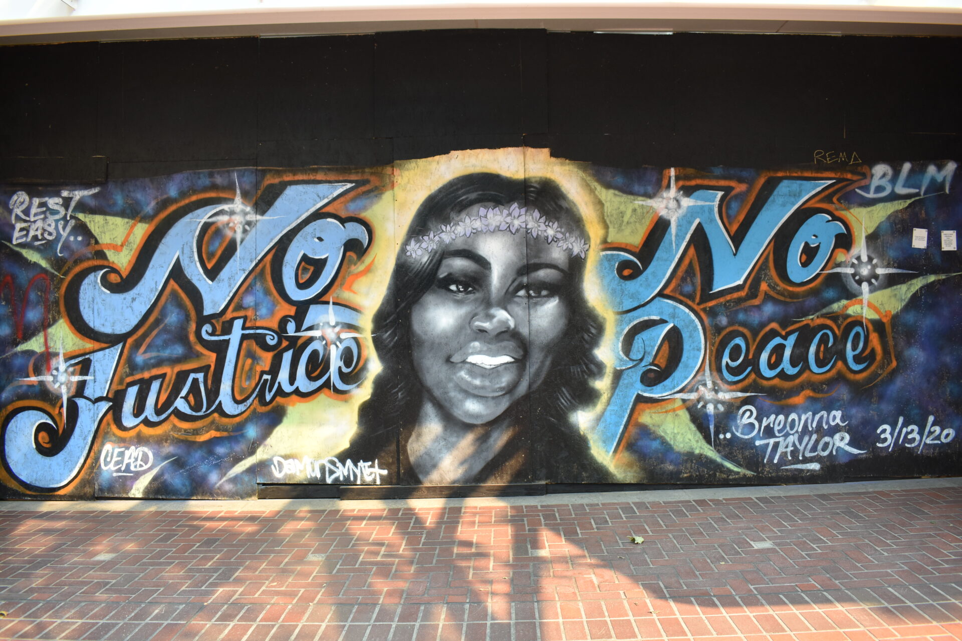 A mural of Breonna Taylor in between the words "No Justice No Peace."