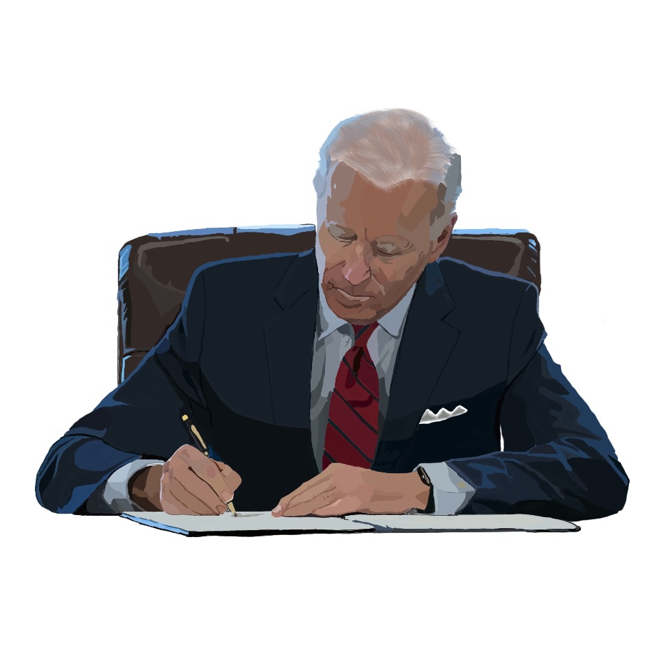 President Joe Biden signs an executive order at his desk in the Oval Office