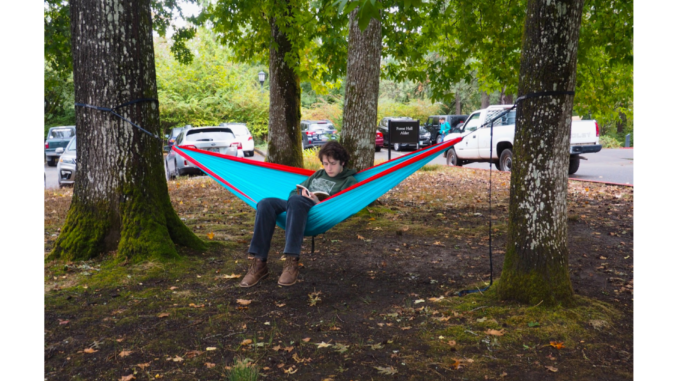 Photo of student in hammock reading a book