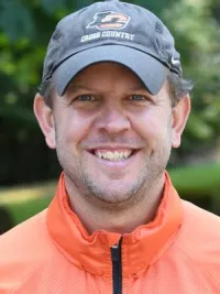 Picture of white man with LC cross country hat smiling