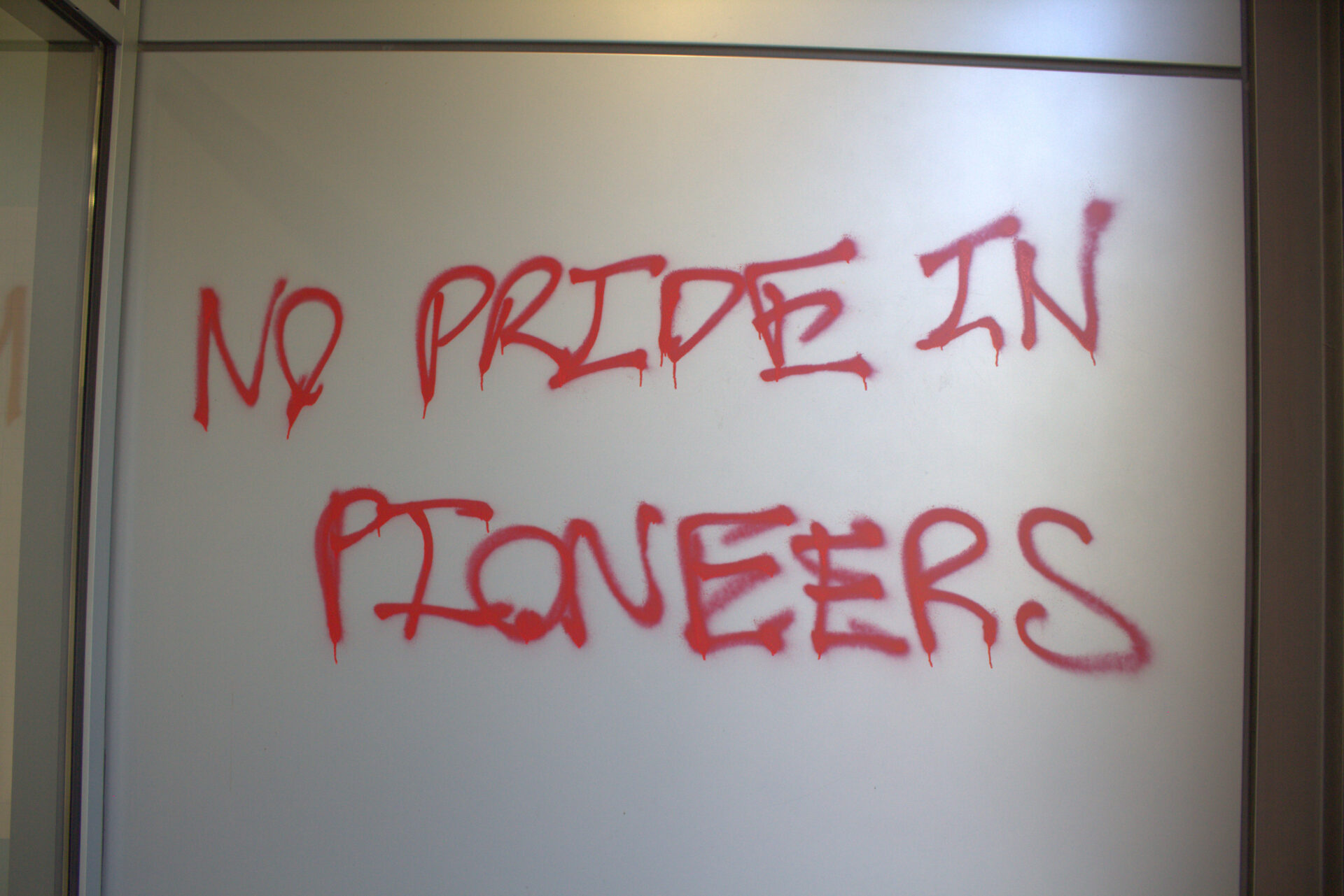 Graffiti on the wall of J. R. Howard reading "No pride in pioneers."
