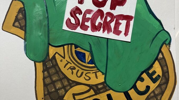 Illustration of a cloth with the words "TOP SECRET" partially covering a police badge.