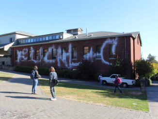 Photo of BoDine building with "Fuck L+C" graffitied on the side.