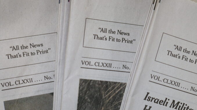 Photo of NYT papers with the text "All The News That's Fit To Print" centered