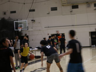 Photo of students playing basketball in intramural uniform (jerseys/non-jerseys)