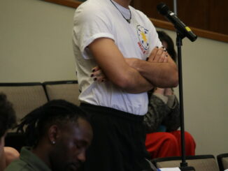 Photo of student asking a question at a symposium