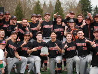 Photo of the baseball team posing with the trophy