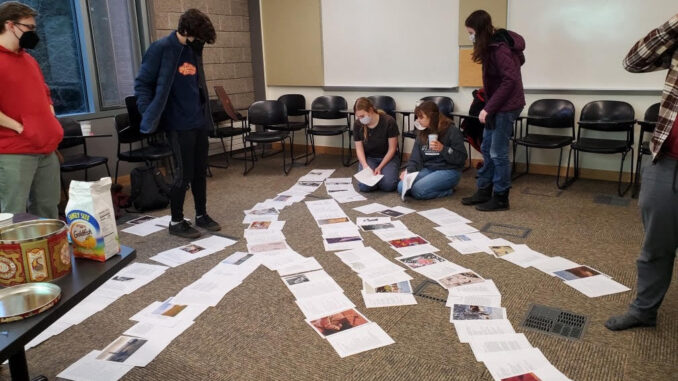 Lit review editors putting together the pages of the review on the floor