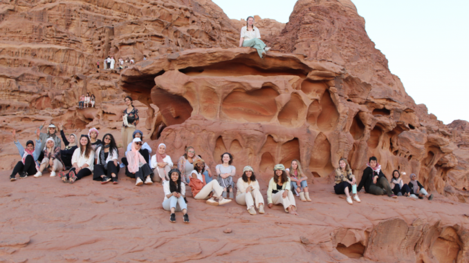 Photo of students on red rocks on a trip to Jordan.