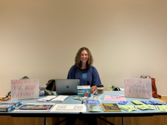 Photo of student running Harm Reduction table