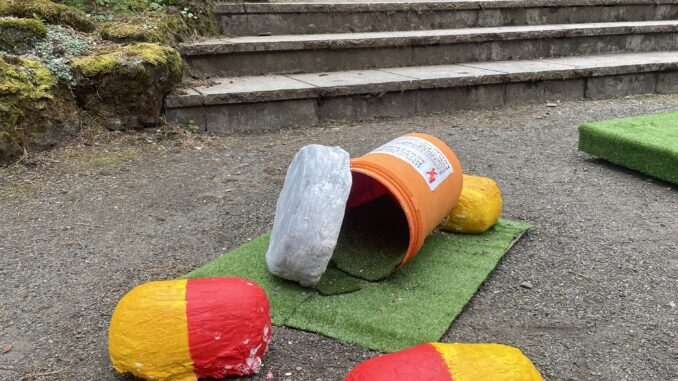 Photo of a pillbottle golf hole with two capsules strewn about as obstacles.